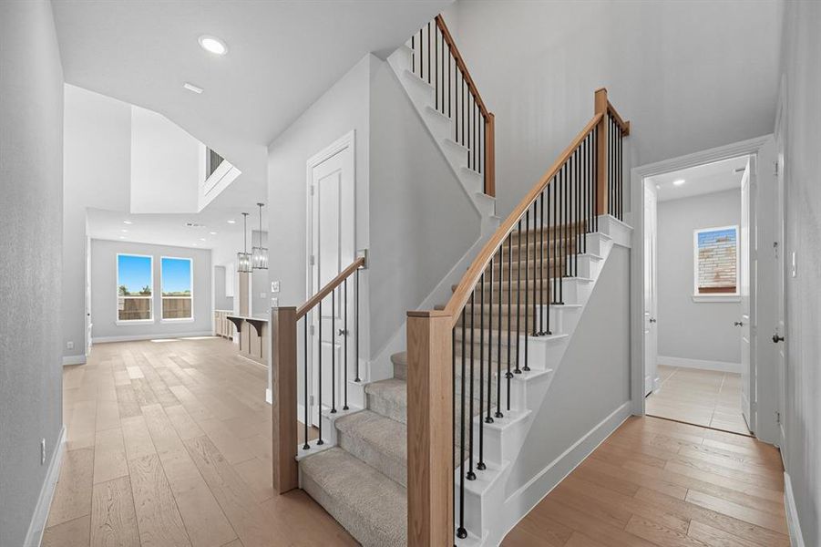 Stairway with hardwood / wood-style floors and recessed lighting