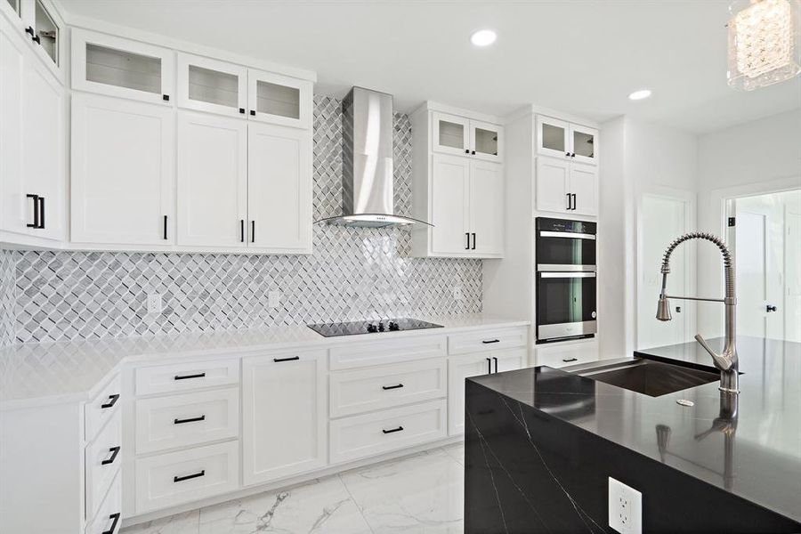 Kitchen with white cabinets, sink, wall chimney range hood, double oven, and black electric stovetop