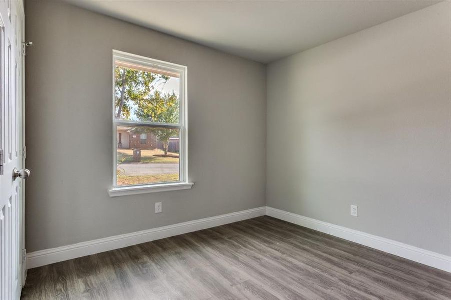 Empty room featuring baseboards and wood finished floors