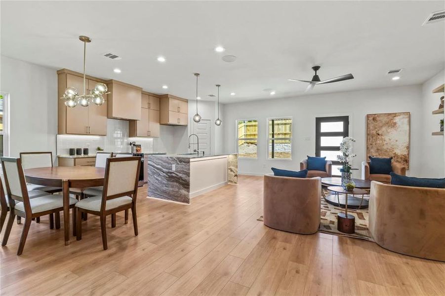 Dining room featuring light wood-style flooring, recessed lighting, a ceiling fan, and a chandelier Dining room featuring light wood-style flooring, recessed lighting, a ceiling fan, and a chandelier