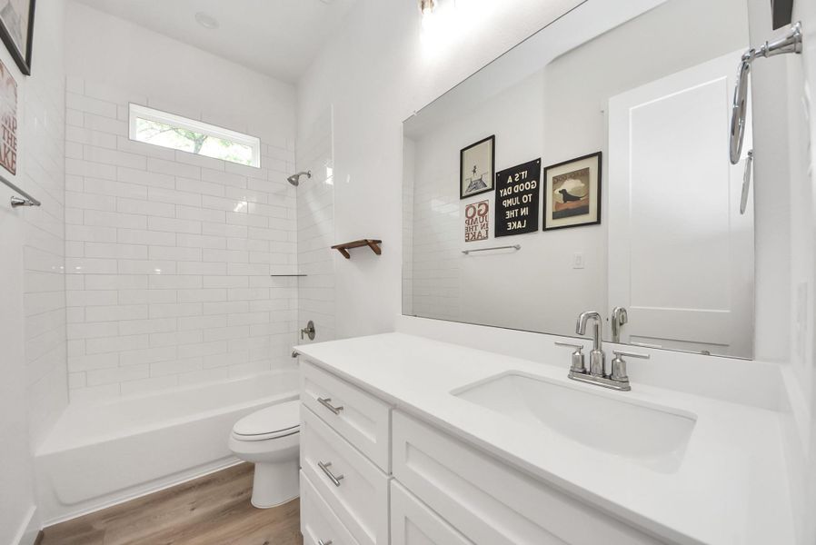 Full hallway bathroom conveniently located between guest bedrooms.