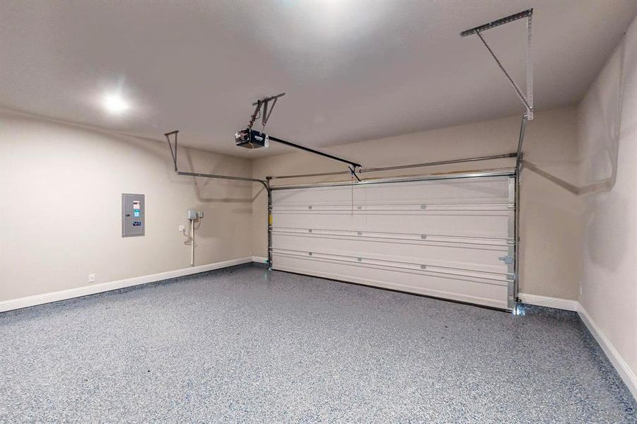 Garage featuring electric panel and a garage door opener