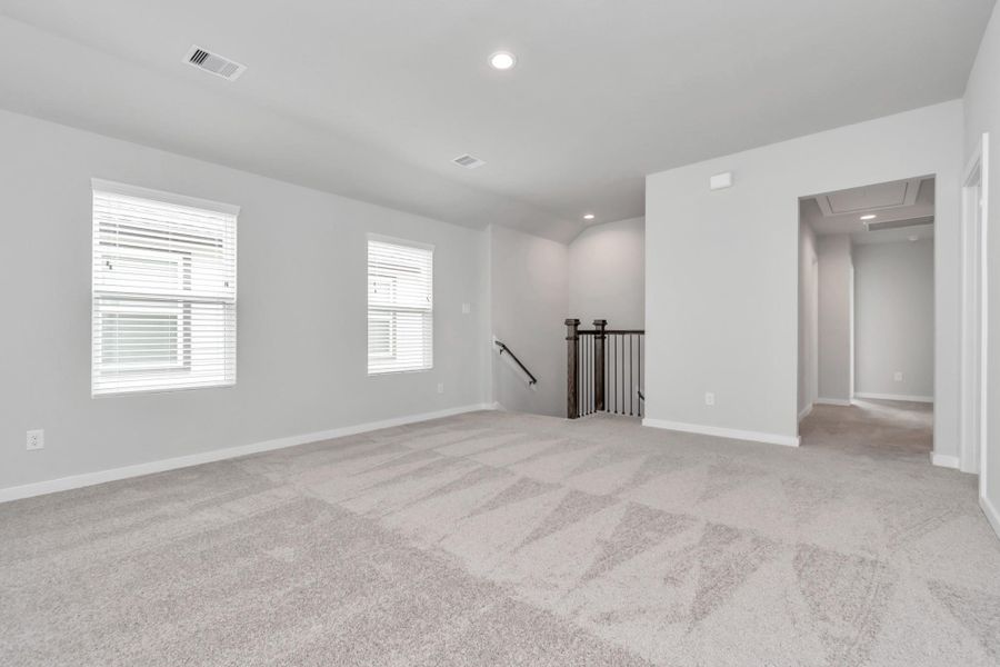Ascend to relaxation in this fantastic game room! Ideal for both casual gatherings and adult gaming, it boasts plush carpet, lofty ceilings, custom paint, and ample windows for abundant natural light. Sample photo of completed home with similar floor plan. Actual colors and selections may vary.