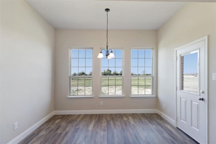 Unfurnished dining area with dark hardwood / wood-style floors and an inviting chandelier