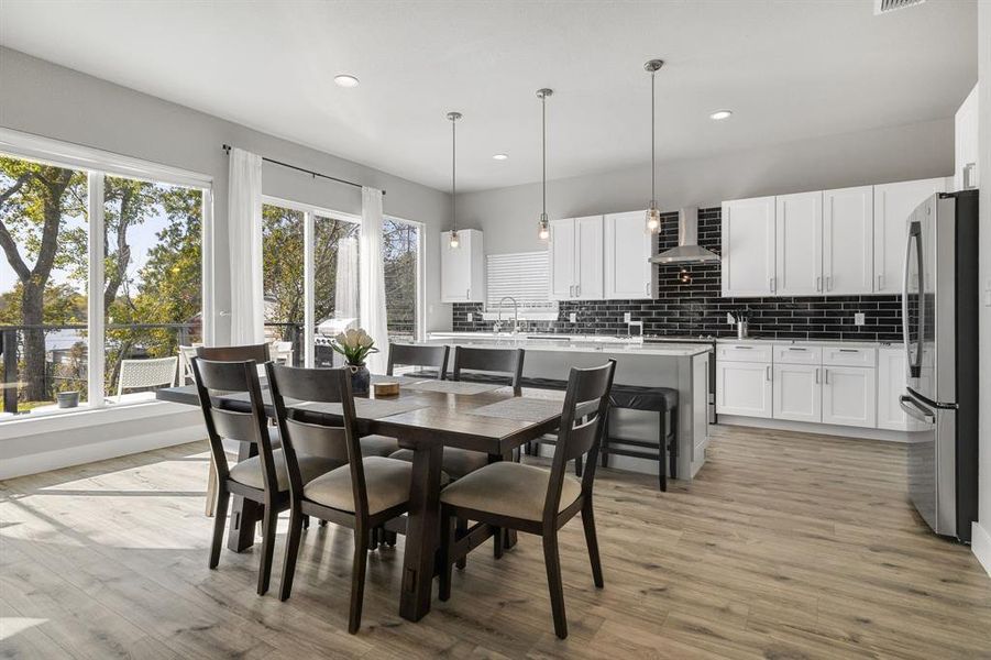 Dining room with light wood-style floors and recessed lighting