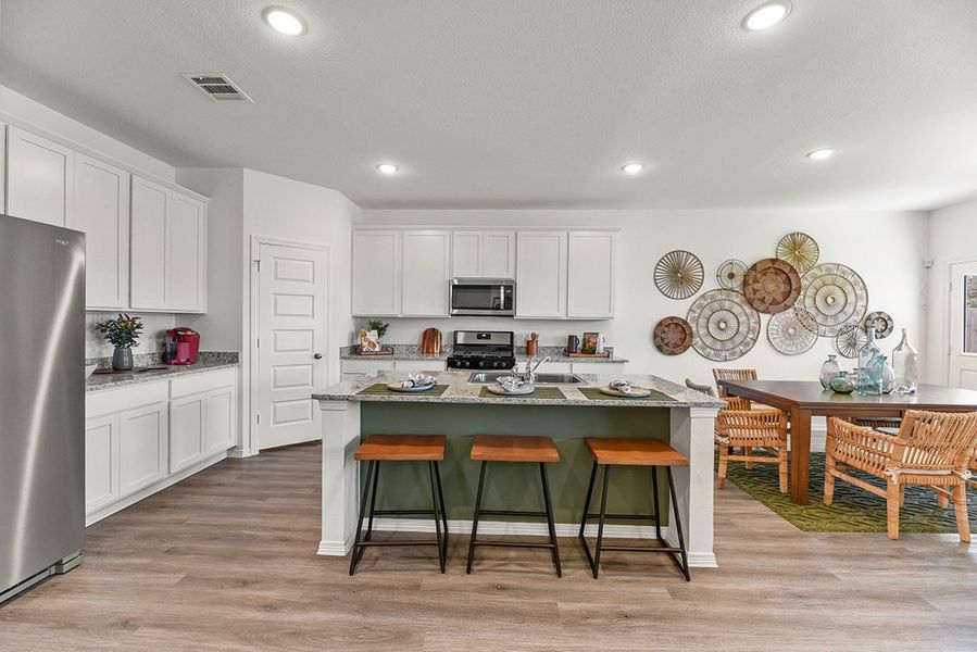 A kitchen with white cabinets and a table with plates on it.