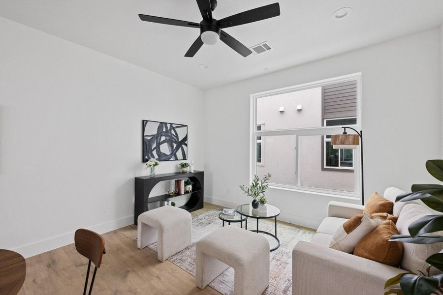 Bright living space featuring white walls and wood-finish flooring