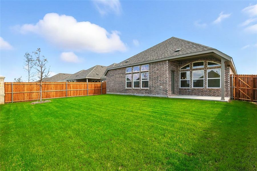 Back of house with a fenced backyard, a patio area, brick siding, and roof with shingles Back of house with a fenced backyard, a patio area, brick siding, and roof with shingles