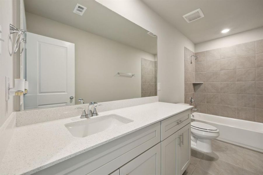 Bathroom with tile patterned flooring, vanity, and toilet