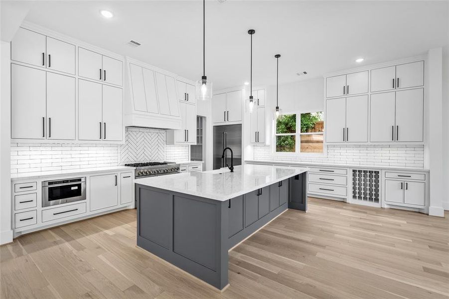 You'll be impressed by the scale and functionality of the kitchen. Equipped w/ quartz countertops, farm sink, JennAir Appliances, under cabinet lighting, recessed outlets underneath the cabinets, space for a wine fridge and soft closing on-site built custom cabinetry.