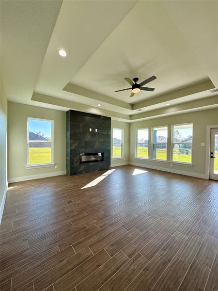 This spacious, sunlit room features a modern tiled floor, a sleek built-in fireplace, and large windows overlooking the backyard. The ceiling has recessed lighting and a contemporary fan, creating an inviting and airy atmosphere. This spacious, sunlit room features a modern tiled floor, a sleek built-in fireplace, and large windows overlooking the backyard. The ceiling has recessed lighting and a contemporary fan, creating an inviting and airy atmosphere.