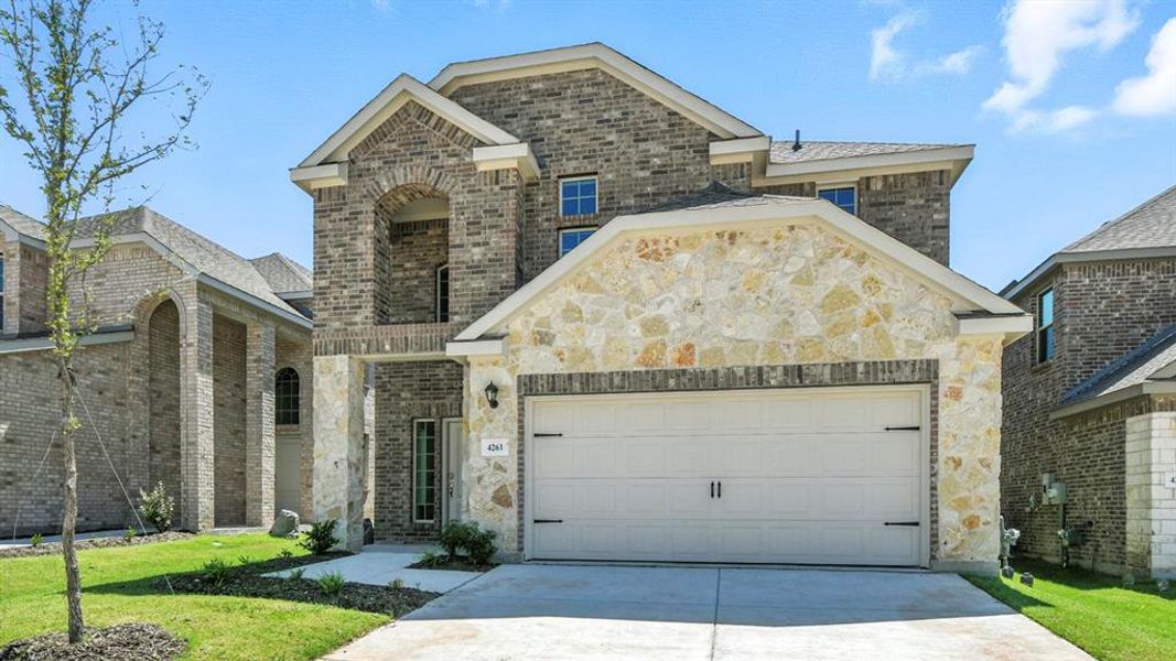 French country home with brick siding, driveway, a front yard, and an attached garage French country home with brick siding, driveway, a front yard, and an attached garage