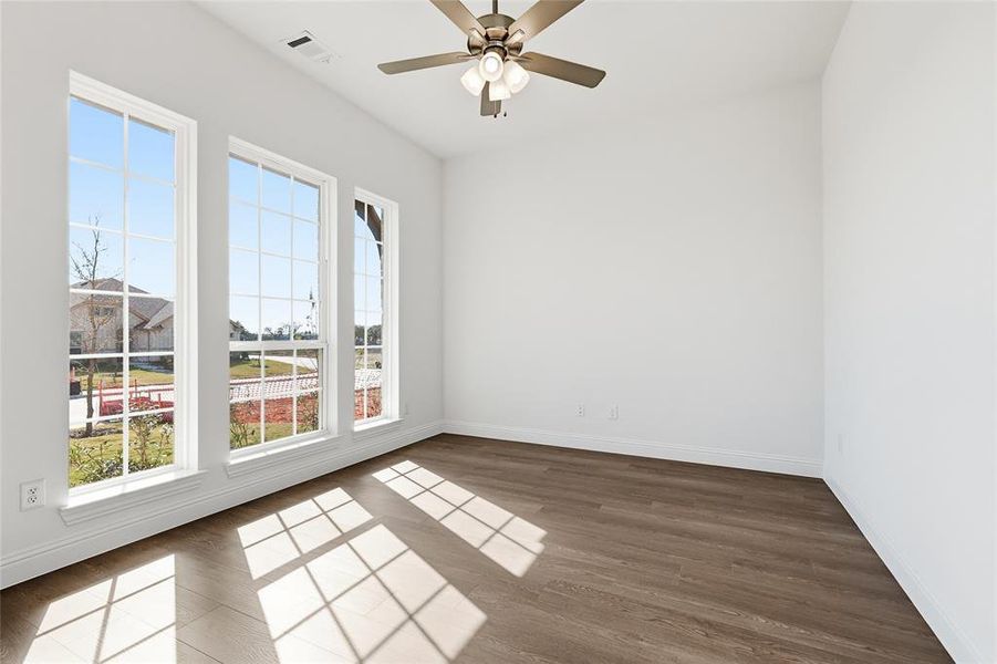 Spare room with dark wood-style flooring and a ceiling fan Spare room with dark wood-style flooring and a ceiling fan