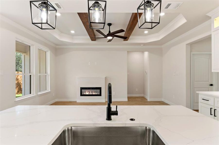 Kitchen with ceiling fan, a wealth of natural light, pendant lighting, and sink