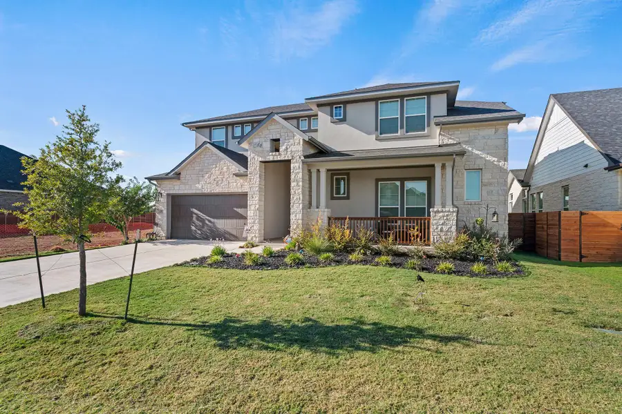 View of front facade with stone siding, driveway, stucco siding, and a porch View of front facade with stone siding, driveway, stucco siding, and a porch