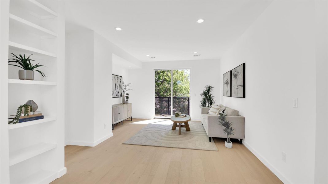Living area with light wood finished floors, built in features, and recessed lighting