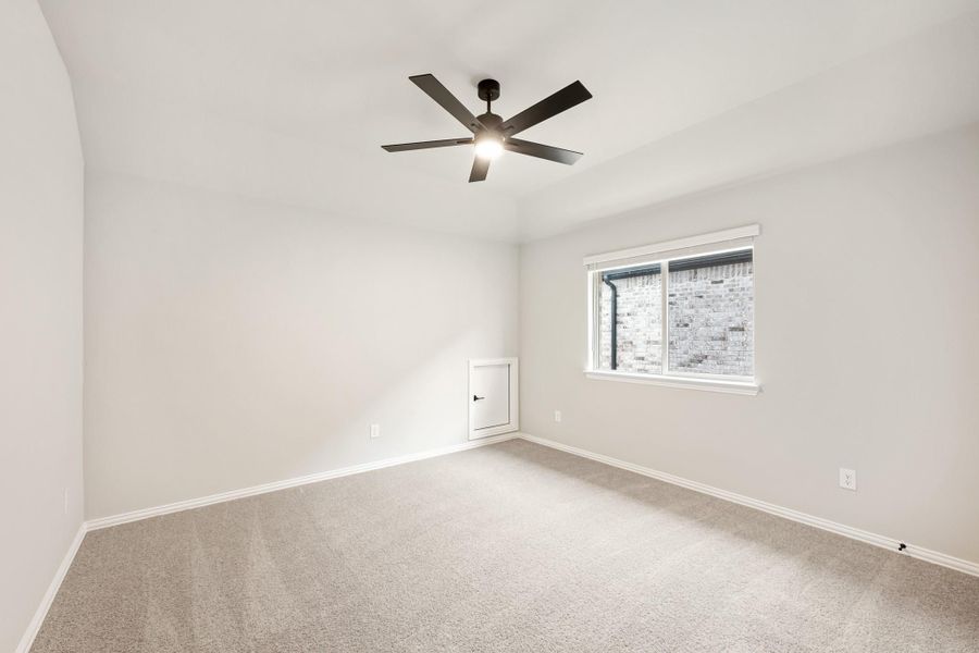 Empty bedroom with carpet flooring, ceiling fan with light, and single window with white walls Empty bedroom with carpet flooring, ceiling fan with light, and single window with white walls