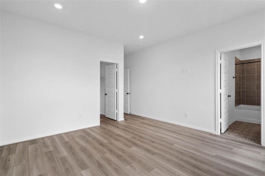 Additional view from primary suite looking towards walk-in closet and ensuite primary bathroom.