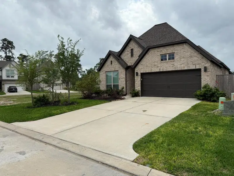 Front exterior of a new home in Grand Central Park 45', Conroe, TX, highlighting curb appeal (Image 2).