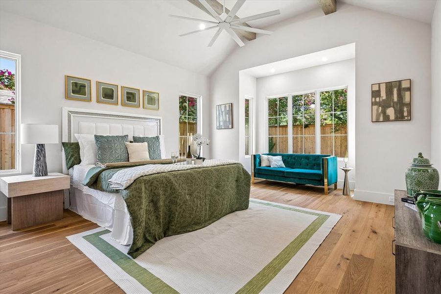 First-floor primary suite, vaulted ceiling with beams, ceiling fan, sitting area, hardwood floors First-floor primary suite, vaulted ceiling with beams, ceiling fan, sitting area, hardwood floors