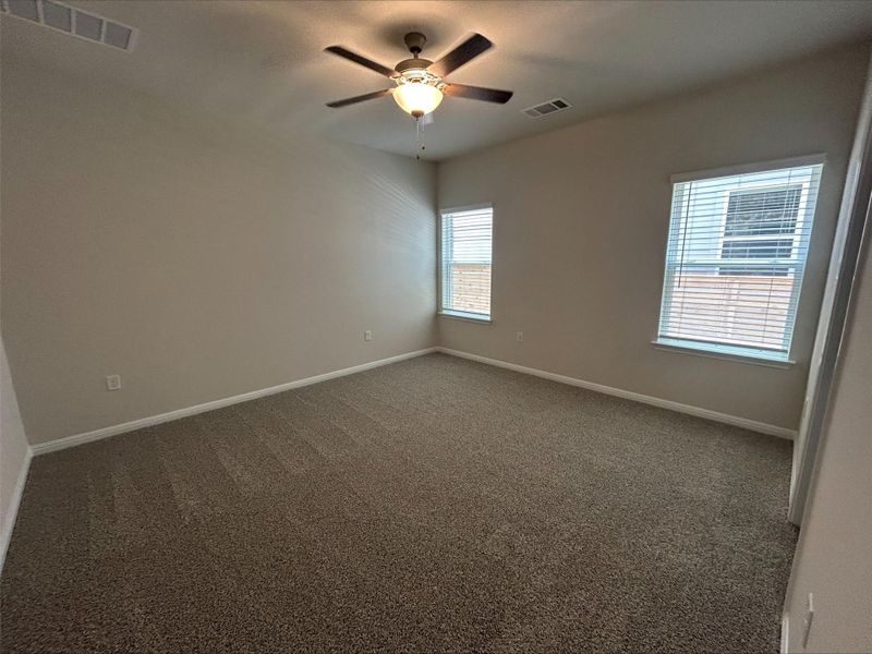 Carpeted spare room with ceiling fan and baseboards Carpeted spare room with ceiling fan and baseboards