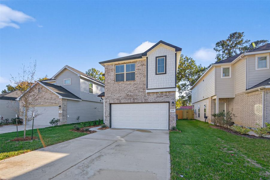 Front exterior of a new home in Woodland Lakes, Huffman, TX, highlighting curb appeal (Image 26). Front exterior of a new home in Woodland Lakes, Huffman, TX, highlighting curb appeal (Image 26).