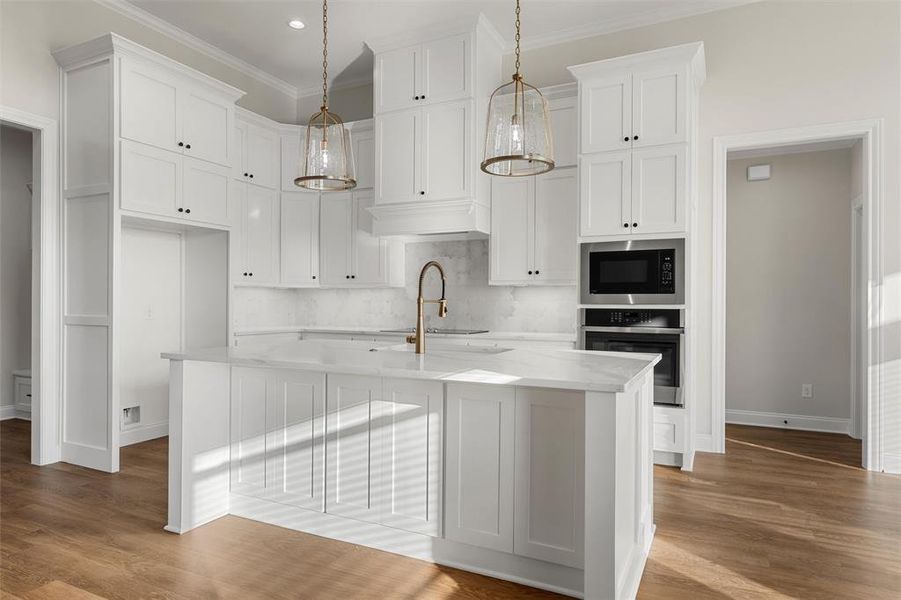 Kitchen featuring oven, backsplash, light wood-style floors, white cabinetry, and pendant lighting Kitchen featuring oven, backsplash, light wood-style floors, white cabinetry, and pendant lighting