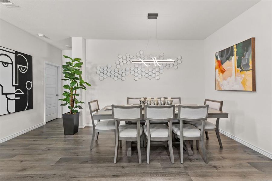 Dining room featuring wood finished floors and a chandelier Dining room featuring wood finished floors and a chandelier