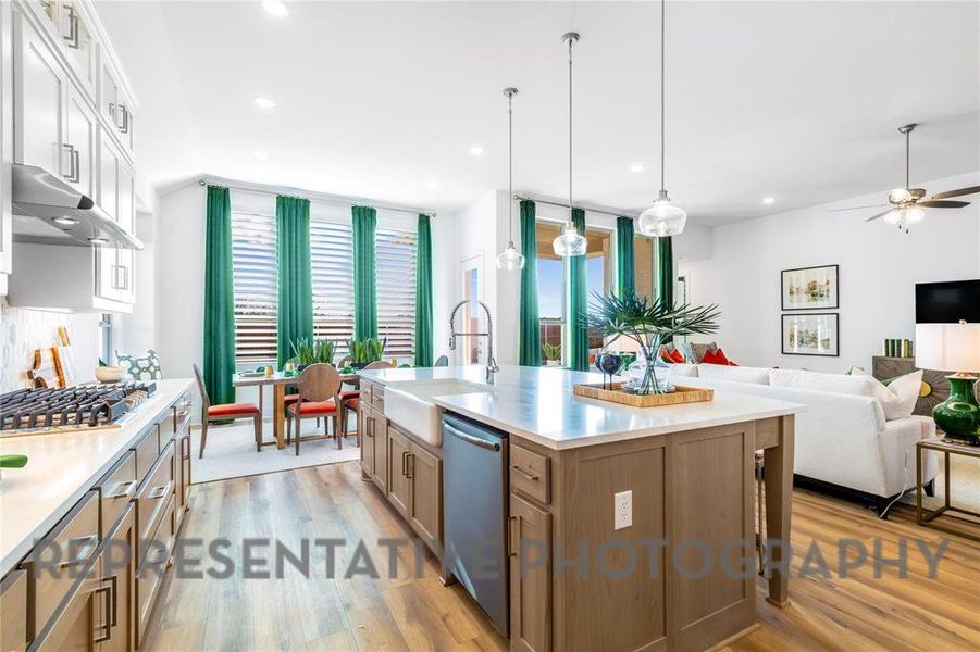 Kitchen featuring light wood finished floors, open floor plan, extractor fan, appliances with stainless steel finishes, and recessed lighting Kitchen featuring light wood finished floors, open floor plan, extractor fan, appliances with stainless steel finishes, and recessed lighting