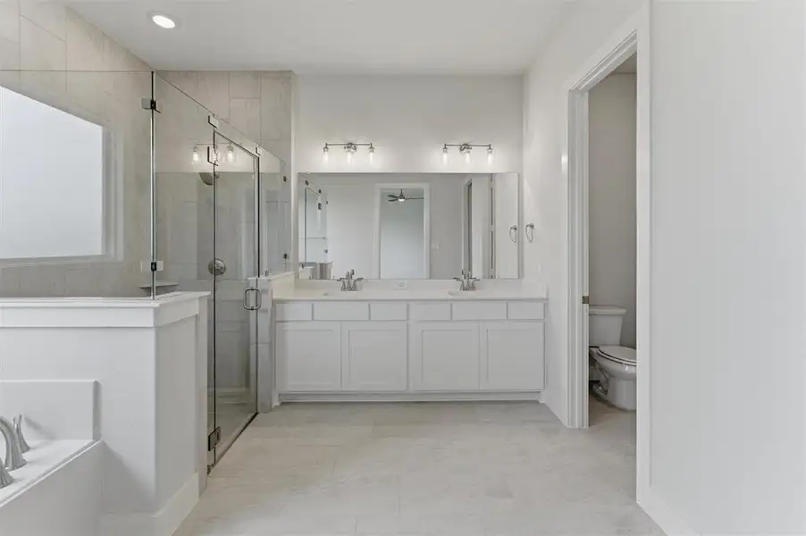 Double vanity with white cabinetry, quartz-finish countertop, and undermount sinks