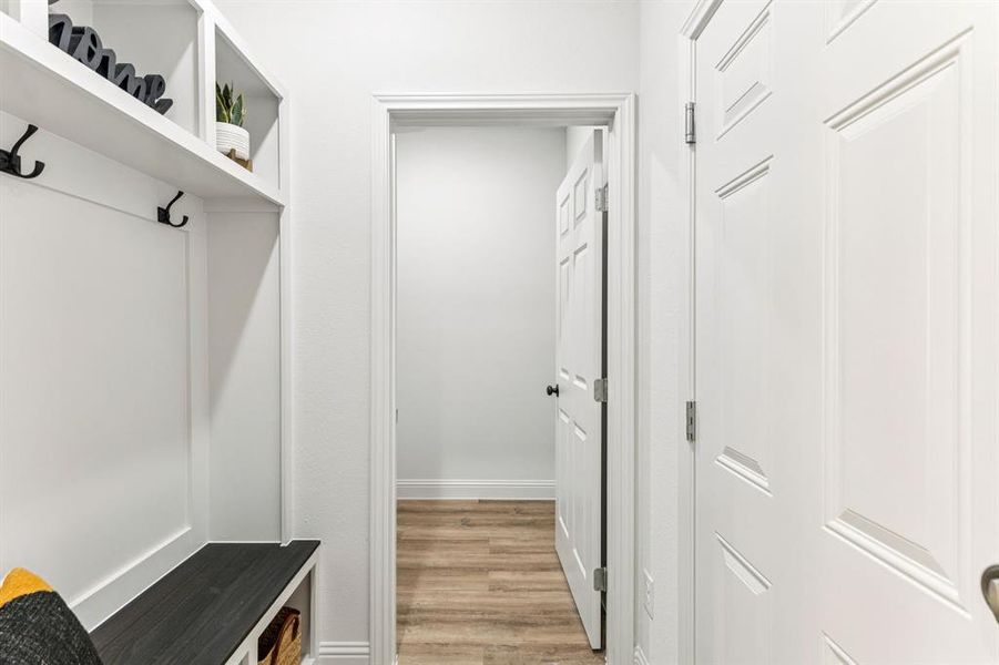 Mudroom with light wood-style flooring and baseboards