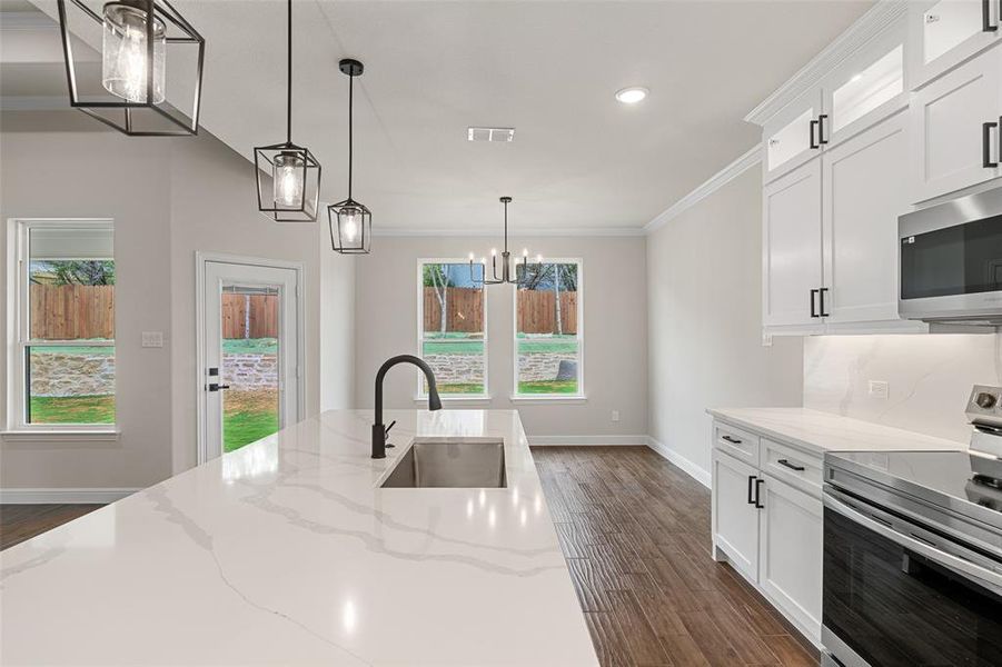 Kitchen with sink, electric stove, dark hardwood / wood-style floors, and a healthy amount of sunlight