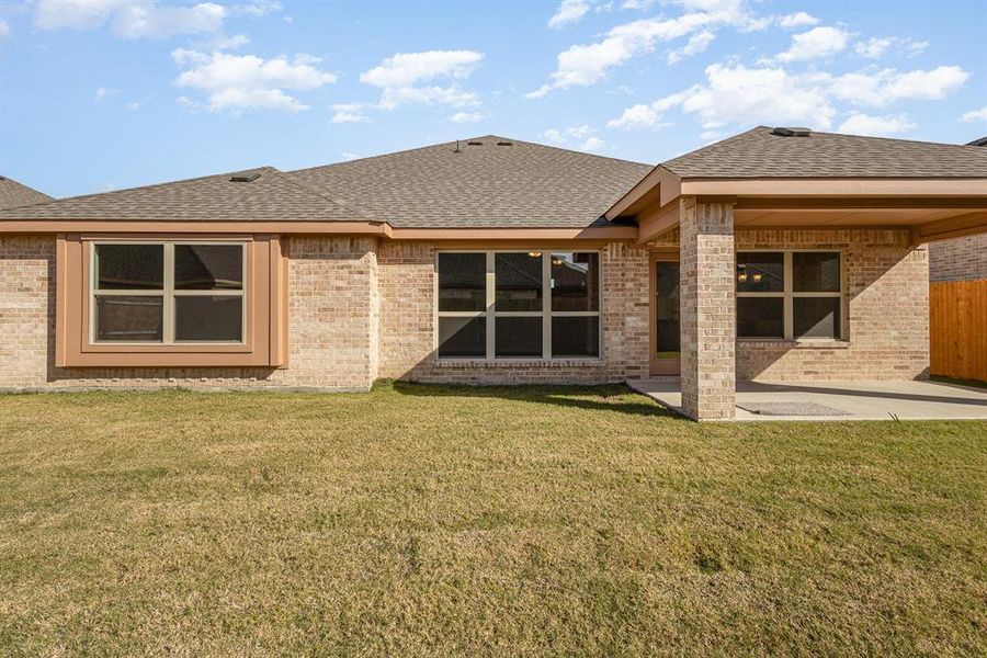 Rear view of house featuring a yard and a patio