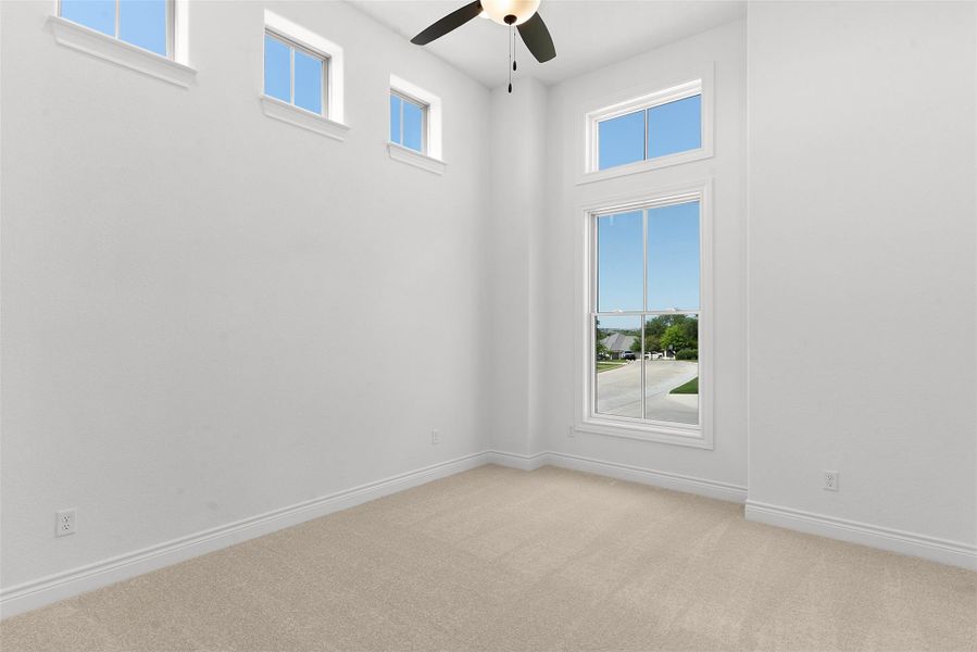 Tall windows and elevated apertures bring ample light into this comfortable bedroom.