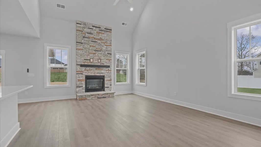 Eye-catching two-story family room with elegant trim, oversized windows, and elevated design located in Woodruff, SC