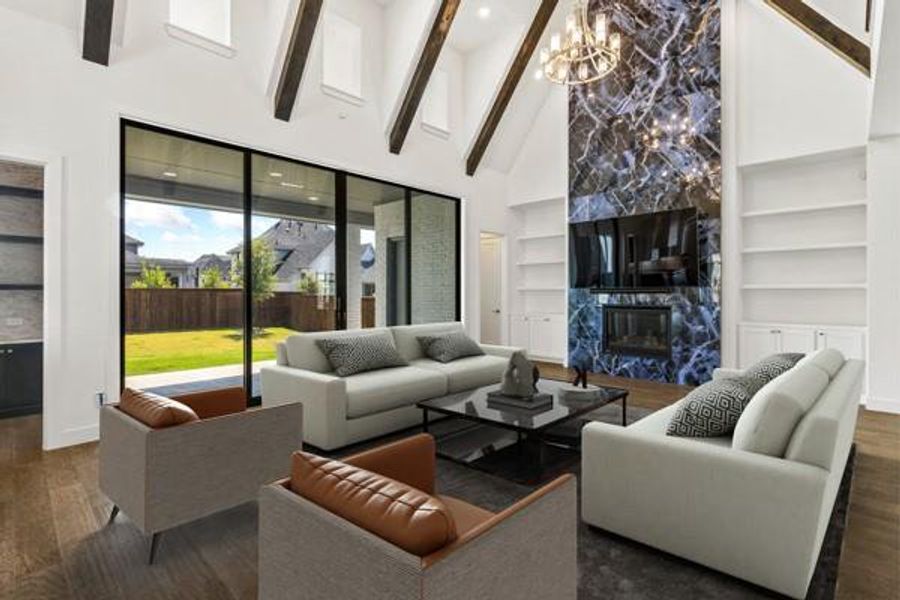 Living area featuring built in features, a premium fireplace, high vaulted ceiling, wood finished floors, and beam ceiling Living area featuring built in features, a premium fireplace, high vaulted ceiling, wood finished floors, and beam ceiling