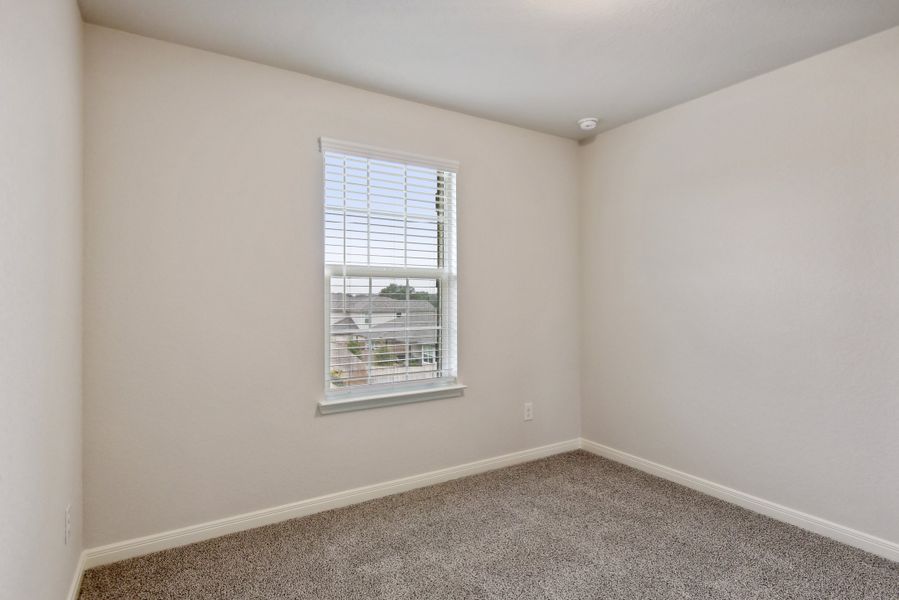 Guest bedroom in the Red River floorplan at a Meritage Homes community.