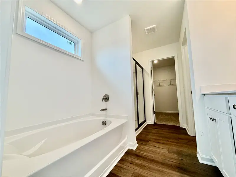Rich wood-look flooring anchors this modern bathro