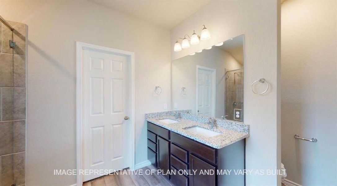 Full bathroom with a shower stall, double vanity, and wood finished floors Full bathroom with a shower stall, double vanity, and wood finished floors