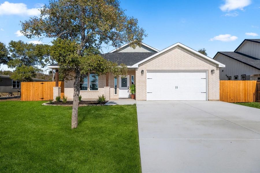 Virtually modified Ranch-style house with brick siding, concrete driveway, an attached garage, and a shingled roof