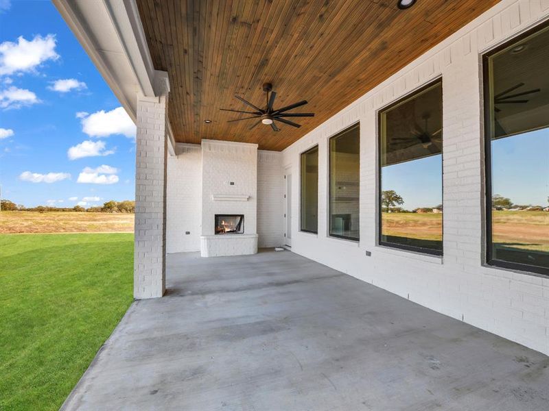 View of patio featuring ceiling fan and an outdoor brick fireplace