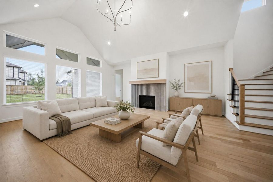 **Virtually Staged** Light-filled living room with soaring ceilings, oversized windows, designer fireplace detail, and an inviting open-concept layout.