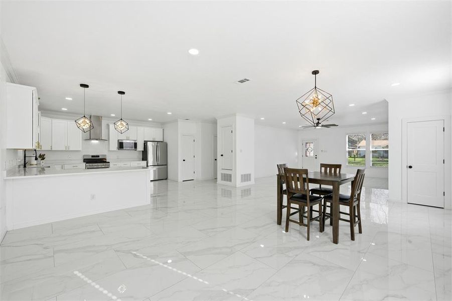 Dining space with light marble finish flooring and recessed lighting Dining space with light marble finish flooring and recessed lighting