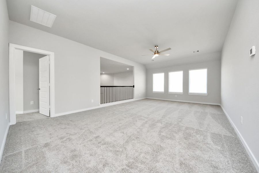 Come upstairs and enjoy a day of leisure in this fabulous game room! This is the perfect hangout spot or adult game room! Features plush carpet, high ceilings, custom paint and windows for plenty of natural light. Sample photo of completed home with similar floor plan. Actual colors and selections may vary.