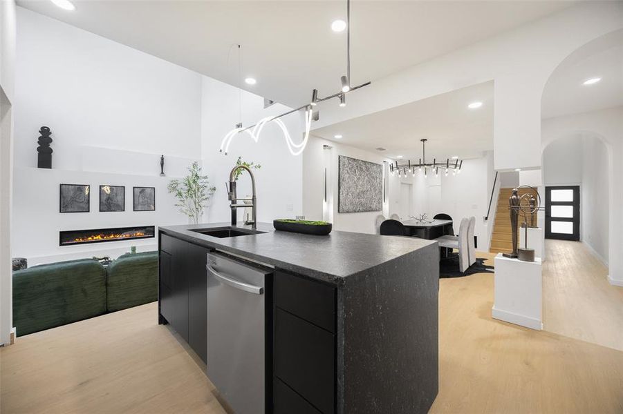 Kitchen featuring dark cabinets, a kitchen island with sink, modern cabinets, light wood finished floors, and recessed lighting