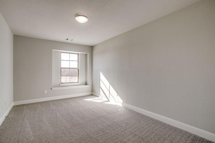 Spare room with baseboards and light carpet