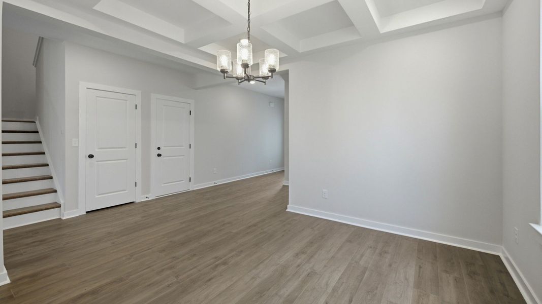 Dedicated laundry area with coffered ceiling and bright natural lighting from windows