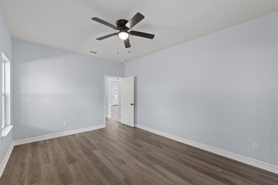 Spare room with dark wood finished floors and ceiling fan