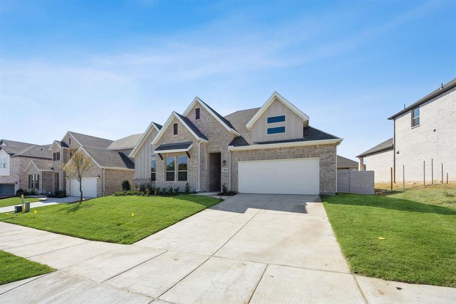 View of front of house featuring a garage and a front lawn