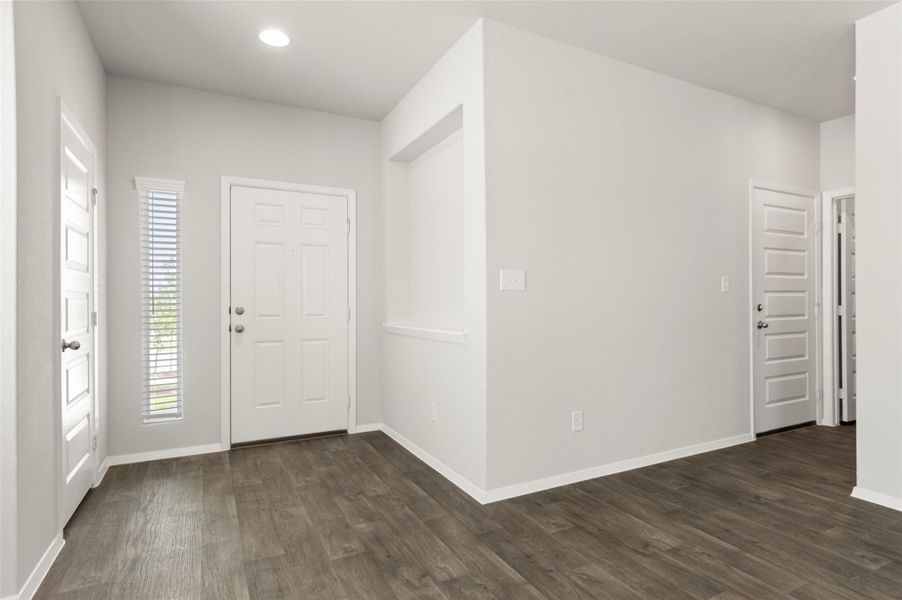 Entryway with dark wood-type flooring and recessed lighting